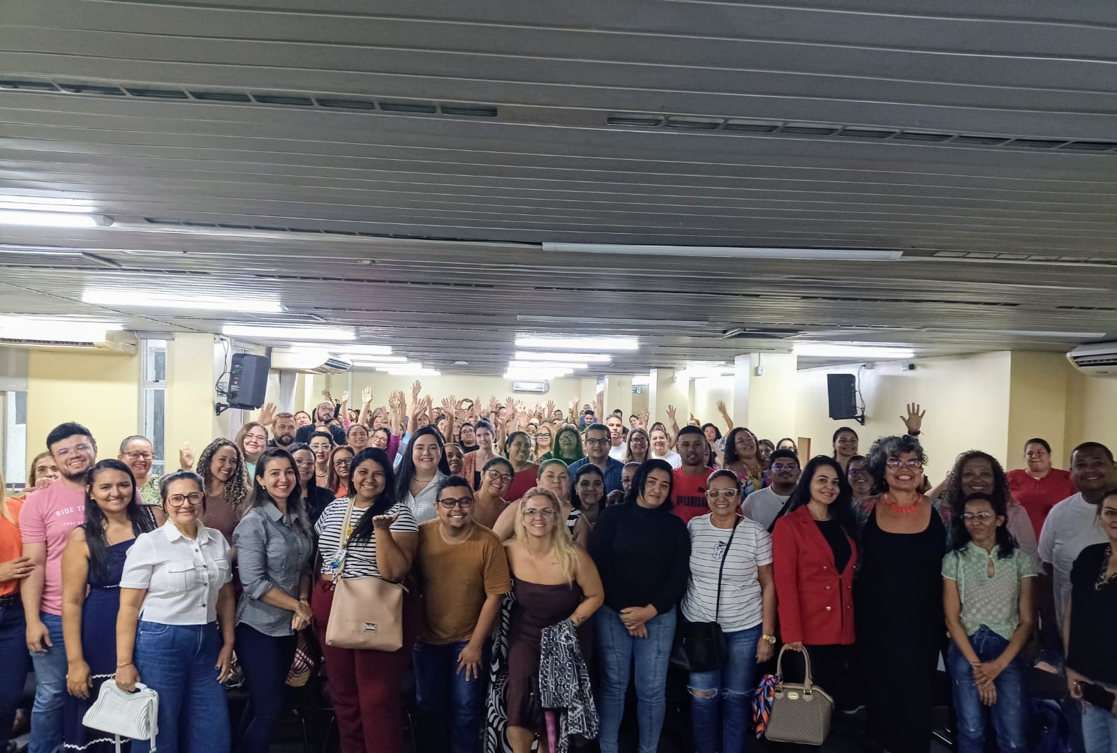 grupo de pessoas posa para a foto em um auditório